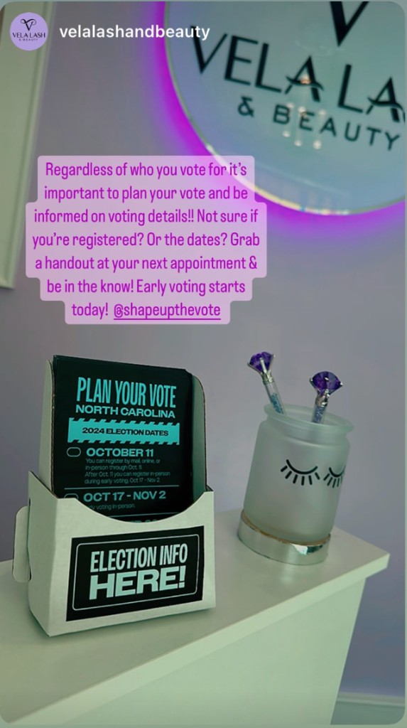 Vela Lash and Beauty election information display with Shape Up The Vote voting handouts